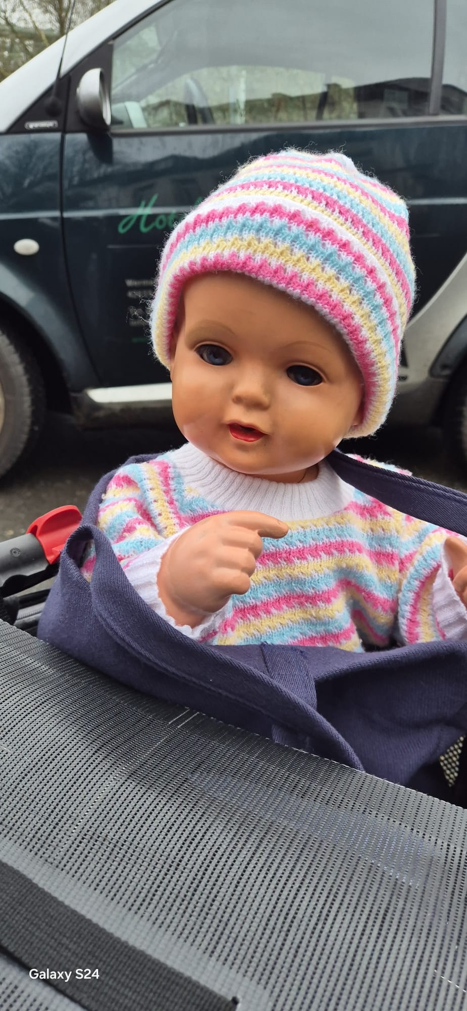 Babypuppe mit bunter Strickmütze – Projekt der Puppenklinik