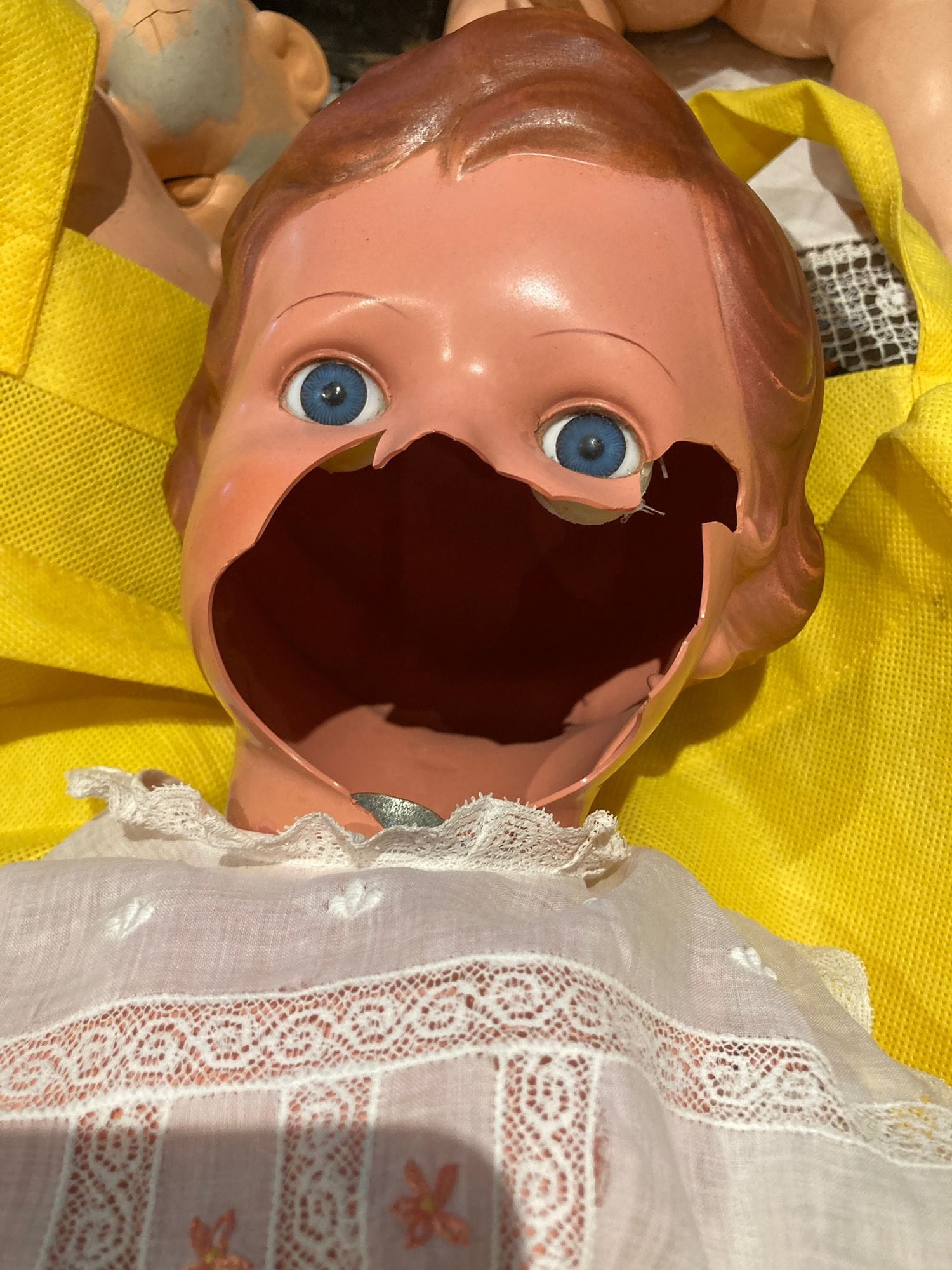 Puppe mit großem Gesichtsschaden vor der Restaurierung